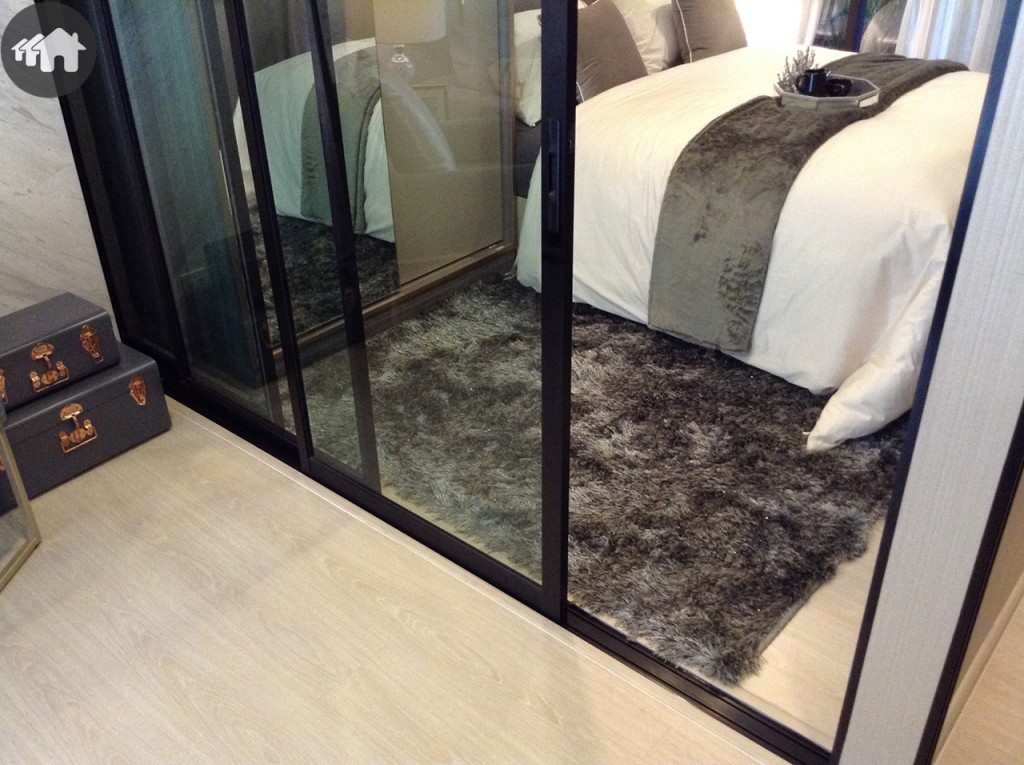 ประตูกระจกบานเลื่อนแบบ 3 ตอน กั้นแบ่งพื้นที่ห้องนอนกับพื้นที่โซนอื่นๆ ไว้อย่างเป็นสัดส่วน
