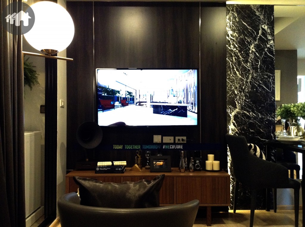 พื้นที่พักผ่อน และรับแขกเชื่อมต่อกับโต๊ะรับประทานอาหารและครัว จัดวางเฟอร์นิเจอร์น้อยชิ้นขนาดกะทัดรัดเพื่อประหยัดพื้นที่และดูไม่เกะกะรกตา ใช้พื้นที่ผนังให้เป็นประโยชน์ด้วยการกรุผนังลายไม้ ติดตั้งทีวีแบบแขวนผนัง ดูไม่เทอะทะ