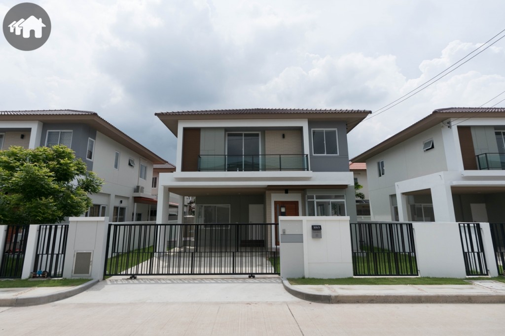 บ้านจริง ด้านหน้าเป็นประตูรั้วเหล็กแบบบานเลื่อน ซึ่งทางโครงการจะปูหญ้าและปลูกต้นมะฮอกกานีให้ด้วย