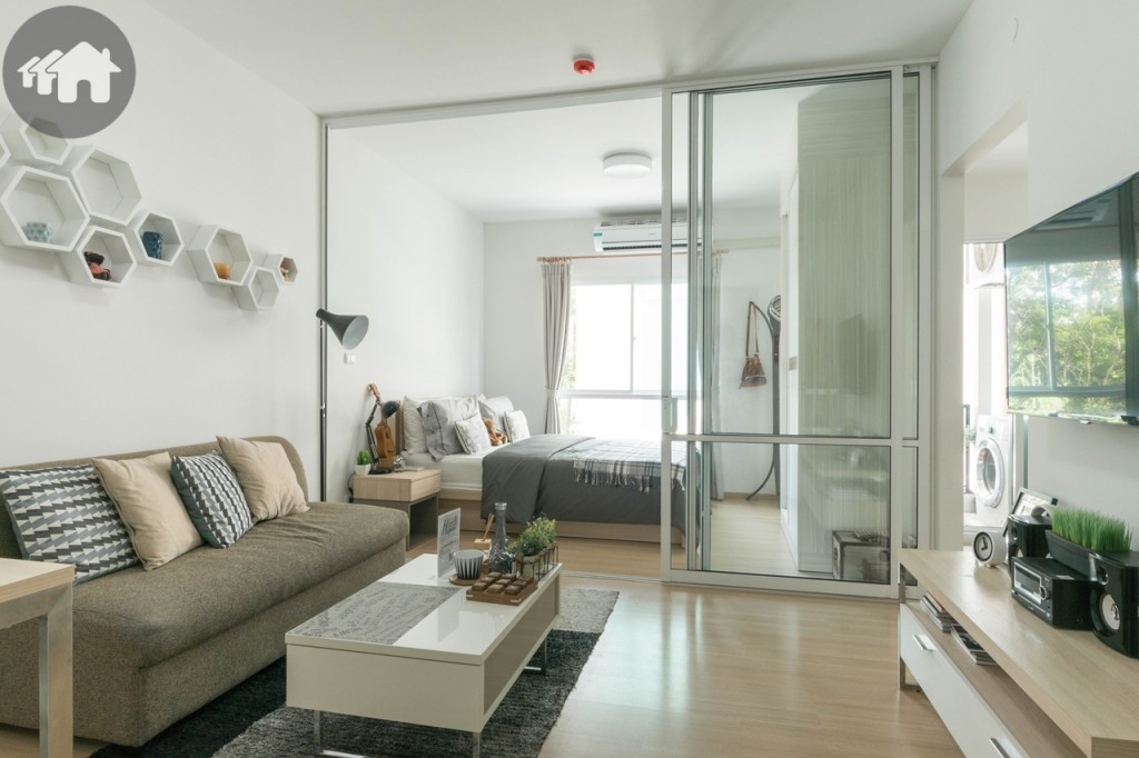 เข้ามาภายในห้อง พื้นห้องนั่งเล่นและห้องนอน พื้นปูลามิเนต หนา 8 มิลลิเมตร เดินนุ่มสบายเท้า และเก็บเสียง โปร่งโล่งด้วยเพดานสูง 2.60 เมตร ผนังห้อง Skim coat ทาสีน้ำอะคลีลิกภายใน โคมไฟแบบกลม