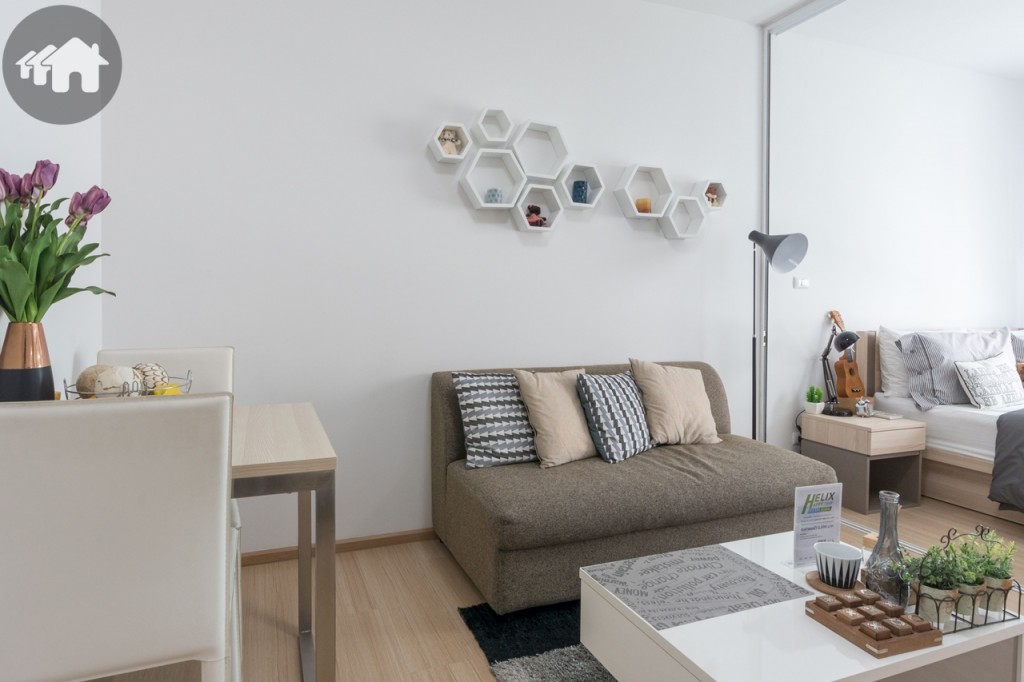 ห้องนั่งเล่น แถมโซฟาขนาด 2 ที่นั่ง ส่วนโต๊ะกลางตกแต่งให้ดูเป็นตัวอย่างเท่านั้น ระยะห่างจากโซฟาถึงชั้นวางโทรทัศน์ประมาณ 2 เมตร