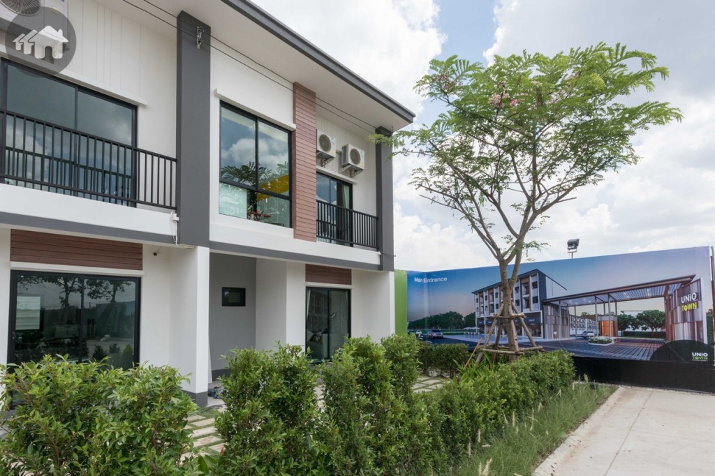 แบบบ้าน AMORE หน้าบ้านจอดรถได้ 1 คัน ตัวบ้านใช้โทนสีเทาและสีน้ำตาลเพื่อให้บ้านดูอบอุ่น พร้อมกับตกแต่งผนังด้วยเส้นเซาะร่อง ลักษณะเหมือนผนังลายไม้ ด้านหน้าเน้นการตกแต่งด้วยเส้นตั้งเพื่อลดทอนความยาวของบ้าน 