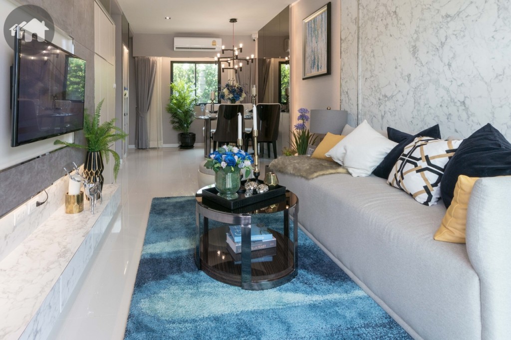 เข้ามาภายในบ้าน จะเป็นส่วนห้องนั่งเล่น เชื่อมต่อกับห้องรับประทานอาหาร โปร่งโล่ง ด้วยเพดานสูงจากพื้น 2.80 เมตร พื้นปูด้วยกระเบื้องแกรนิตโต้แผ่นใหญ่