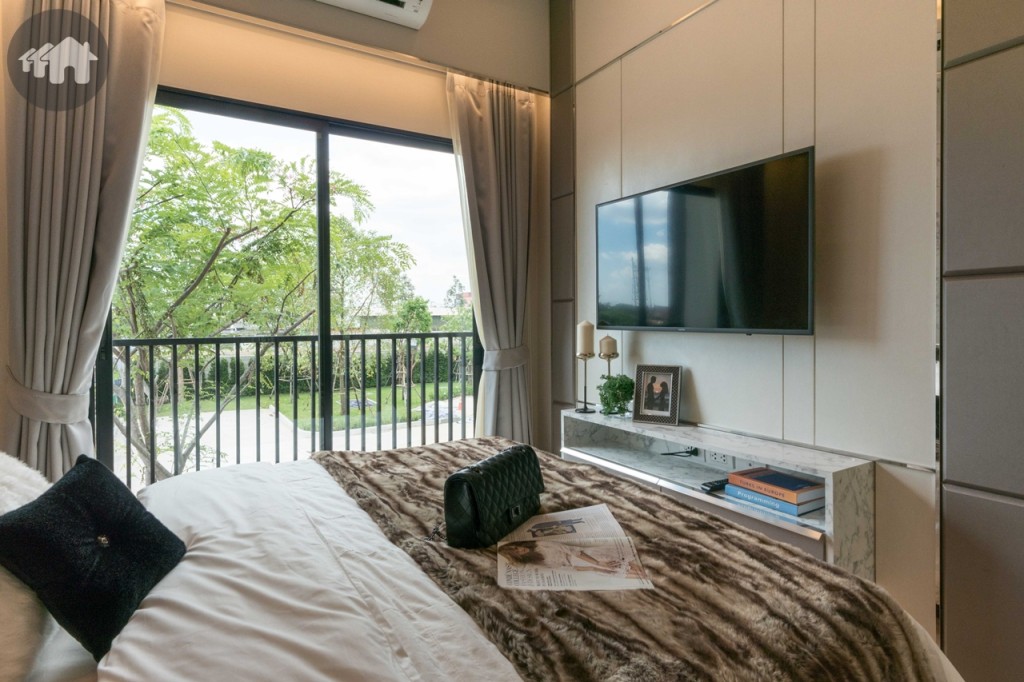 ปลายเตียงติดตั้งโทรทัศน์แบบแขวนผนัง พร้อมชั้นวางของ ชั้นวางห่างจากปลายเตียงประมาณ 60 เซนติเมตร