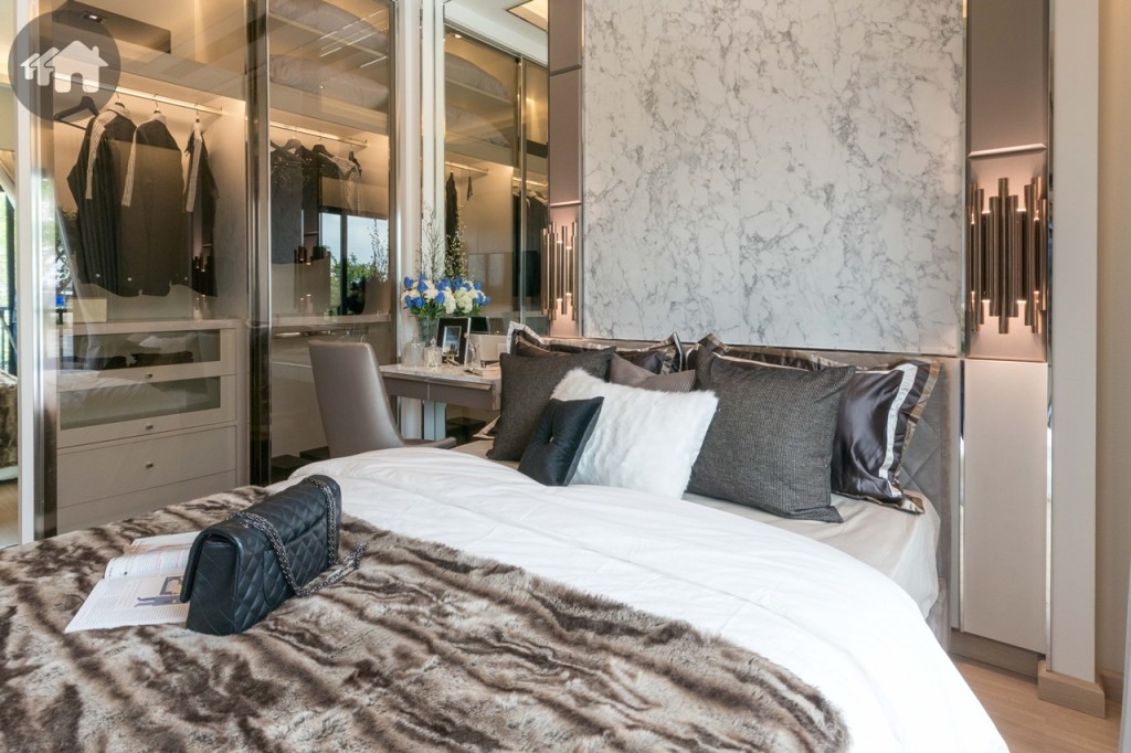 ข้างเตียงด้านที่ติดตู้เสื้อผ้า กว้างประมาณ 1 เมตร ตกแต่งเป็นมุมโต๊ะทำงาน อีกด้านกว้างประมาณ 60 เซนติเมตร ติดกับประตูกระจกบานเลื่อนแบบสลับบานใหญ่ เชื่อมกับระเบียง