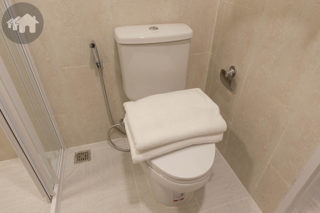 โถสุขภัณฑ์ของ Cotto พร้อมสายฉีดชำระ และที่แขวนกระดาษชำระ