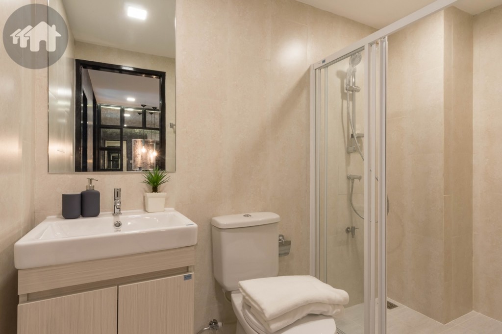 อีกด้านของห้องนั่งเล่นติดกับห้องน้ำ เพดานสูงประมาณ 2.20 เมตร ขอบประตูยกสูงประมาณ 7 เซนติเมตร พื้นปูกระเบื้องเซรามิก ขนาด 30x30 เซนติเมตร ผนังปูกระเบื้องเซรามิก ขนาด 30x60 เซนติเมตร พร้อมอุปกรณ์ครบครันของ Cotto พื้นที่อาบน้ำกั้นด้วยกระจกเทมเปอร์เป็นสัดส่วน ขอบประตูยกพื้นสูงประมาณ 4 เซนติเมตร กว้างประมาณ 1.15 เมตร ยาวประมาณ 1.35 เมตร