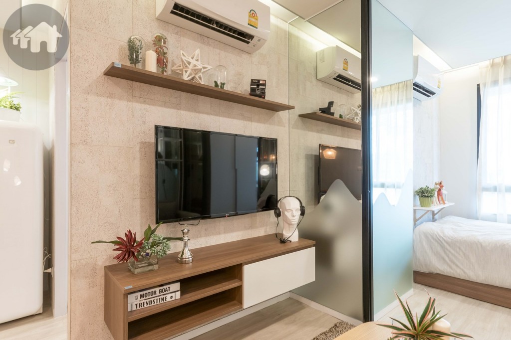 ตรงข้ามเป็นชั้นวางโทรทัศน์ และชั้นวางของเหนือโทรทัศน์ ที่มาพร้อมกับห้อง ห่างจากโซฟาประมาณ 1.40 เมตร