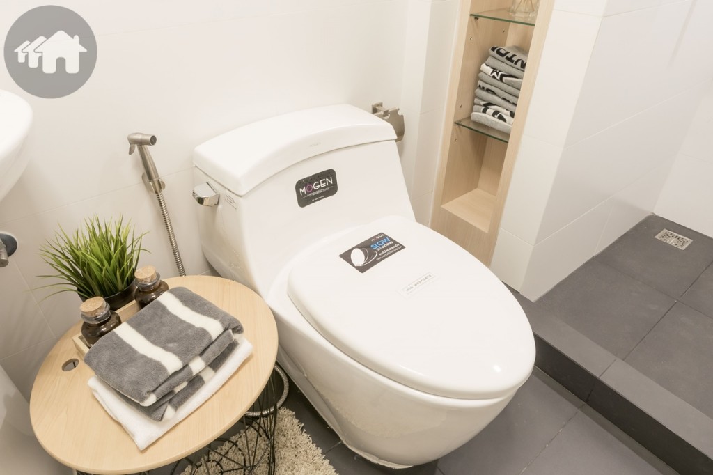 โถสุขภัณฑ์ของ Mogen พร้อมสายฉีดชำระ และที่ใส่กระดาษชำระ ด้านข้างยังเหลือพื้นที่ให้วางโต๊ะเล็กๆ ได้ด้วย