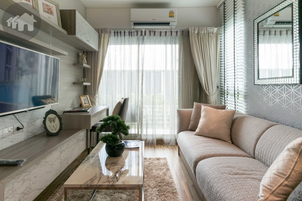 ถัดจากเคาน์เตอร์ครัว เป็นห้องนั่งเล่นขนาดใหญ่ โซฟาห่างจากชั้นวางโทรทัศน์ประมาณ 1.30 เมตร