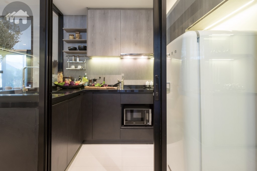 ฝั่งตรงข้ามเป็นห้องครัว กั้นด้วยผนังกระจกใสเข้ามุม ให้ความโปร่งโล่ง เชื่อมต่อด้วยประตูกระจกบานเลื่อนแบบสลับ พื้นและผนังปูกระเบื้องขนาด 60x60 เซนติเมตร พื้นที่ทางเดินกว้างและยาวประมาณ 1.20 เมตร