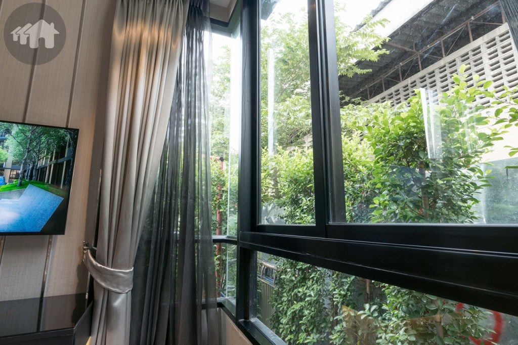 ด้านข้างเตียงติดกับกระจกบานเลื่อนแบบสลับ และเพิ่มมุมมองให้กว้างขึ้นด้วยผนังกระจกเข้ามุม