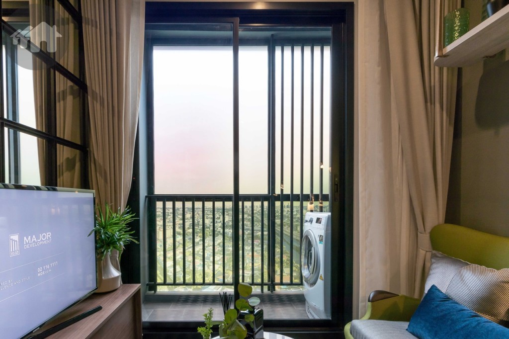 ห้องนั่งเล่นเชื่อมต่อกับระเบียงด้วยประตูบานเลื่อนแบบสลับกรอบอะลูมิเนียม Powder coated ขอบประตูยกพื้นสูงประมาณ 15 เซนติเมตร