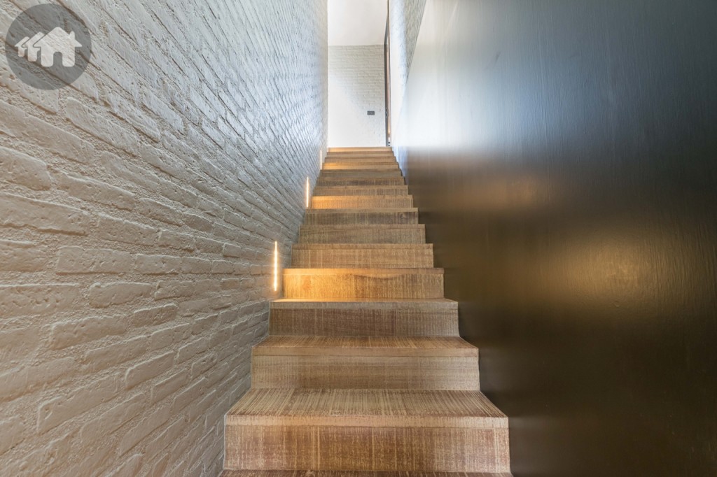 บันไดสู่ชั้นล่าง มีไฟส่องสว่างฝังไปกับผนัง เรียบง่าย และช่วยประหยัดไฟด้วยหลอดไฟแบบ LED