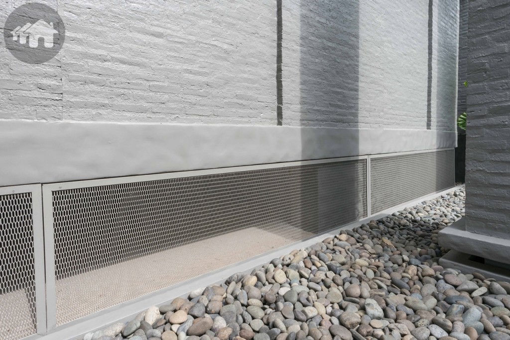 ตัวอาคารยกสูงจากพื้นดิน 50 เซนติเมตร พร้อมติดตั้งตะแกรงเหล็กฉีก เพื่อป้องกันความชื้นเข้าสู่ตัวบ้าน และง่ายต่อการซ่อมบำรุงในอนาคต ด้านข้างโรยหินธรรมชาติเพิ่มความสวยงาม