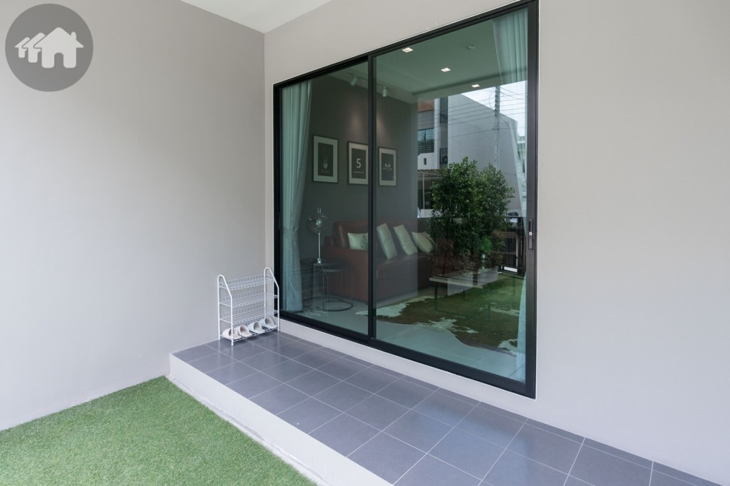 ตัวบ้านยกพื้นสูงจากที่จอดรถ ประตูกระจกบานเลื่อนแบบสลับ บานใหญ่