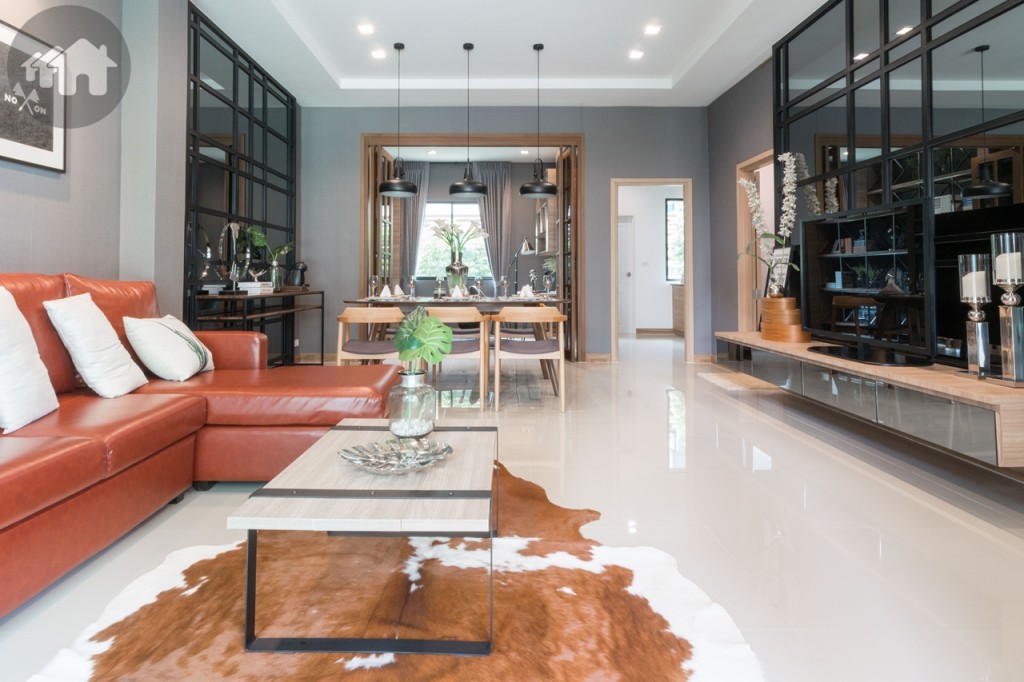 เข้ามาภายในบ้านเป็นห้องนั่งเล่น เปิดพื้นที่เชื่อมต่อห้องรับประทานอาหาร พื้นปูกระเบื้องแกรนิตโต้แผ่นใหญ่ โปร่งโล่งด้วยความสูงจากพื้นถึงเพดาน 2.85 เมตร เพดานดรอปฝ้าให้ด้วย
