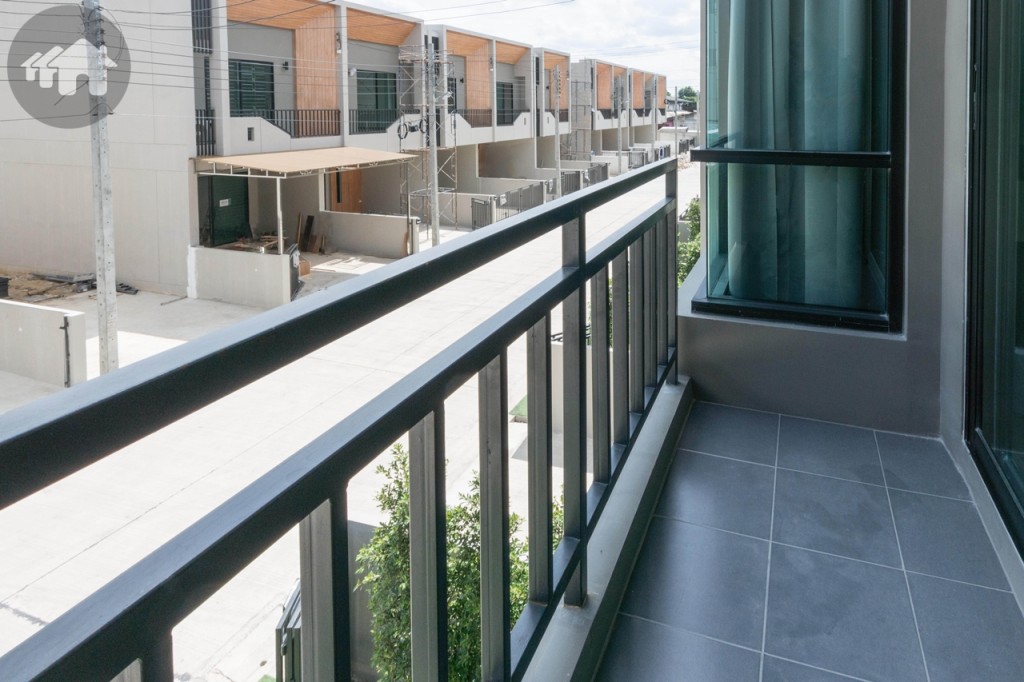 ระเบียงยาวประมาณ 3.5 เมตร กว้างประมาณ 80 เซนติเมตร พื้นปูกระเบื้องขนาด 30x30 เซนติเมตร รั้วเหล็กสูงประมาณ 90 เซนติเมตร อีกด้านวางคอมเพรสเซอร์เครื่องปรับอากาศ