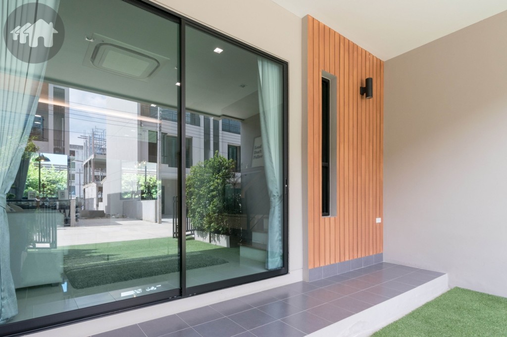ตัวบ้านยกพื้นสูงจากที่จอดรถ ประตูกระจกบานเลื่อนแบบสลับ บานใหญ่