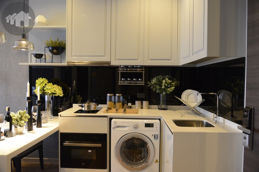 ส่วนครัวจะอยู่ติดประตู เคาน์เตอร์ครัวรูปตัว L มี Built-in เก็บของลอยด้านบน พร้อมช่องใส่เครื่องซักผ้าและเตา ถัดไปข้างๆมีโต๊ะทานอาหาร สำหรับนั่งได้ 2 คน