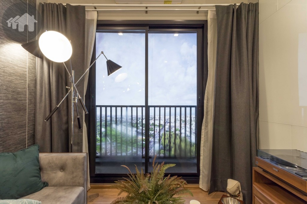 ห้องนั่งเล่นเชื่อมต่อกับระเบียงด้วยประตูกระจกกรอบอะลูมิเนียม Powdered Coating แบบบานเลื่อนสลับบานใหญ่ ขอบประตูยกสูงประมาณ 15 เซนติเมตร