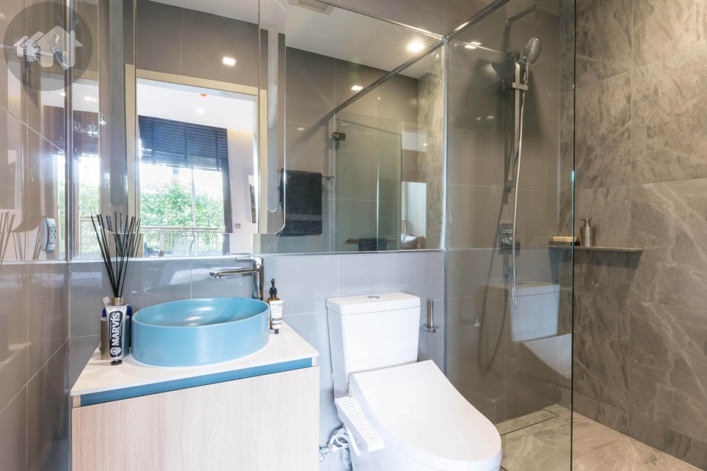 ห้องน้ำขนาดใหญ่ ดร็อปพื้นจากห้องนอนประมาณ 3 เซนมิเมตร พื้นและผนังปูกระเบื้องลายหินขนาด 60x60 เซนติเมตร ห้องใหญ่ตกแต่งด้วยกระจกบานใหญ่ มาพร้อมระบบเปิด-ปิดไฟอัตโนมัติบริเวณบานกระจกเพียงแค่โบกมือผ่านเซนเซอร์ด้านล่าง