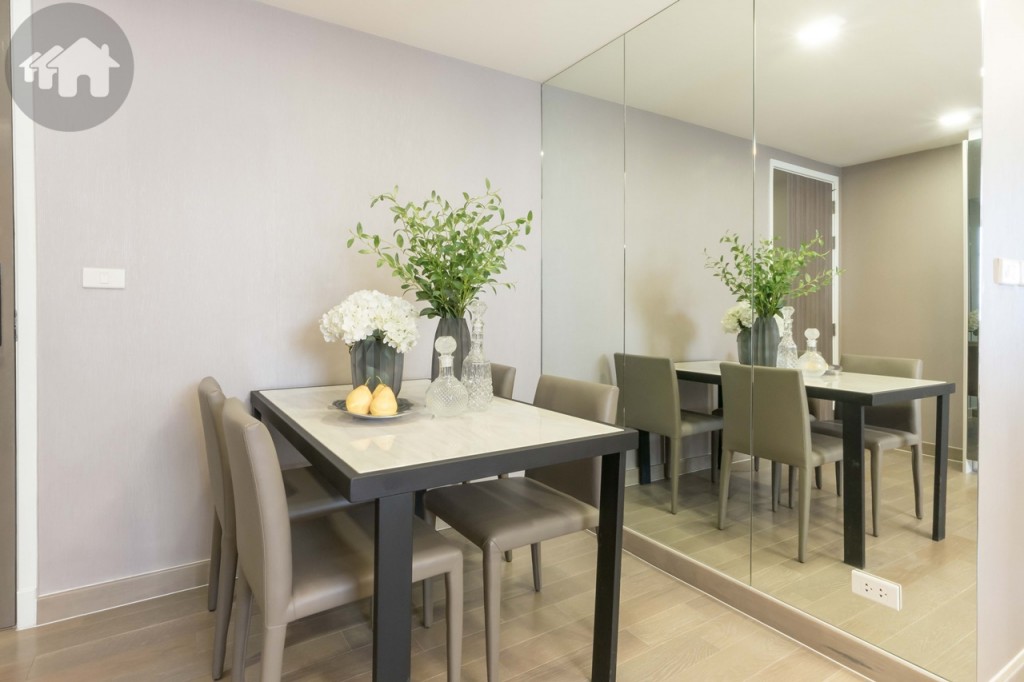 Opposite the dining table are a mirrored closet and shoes cabinet