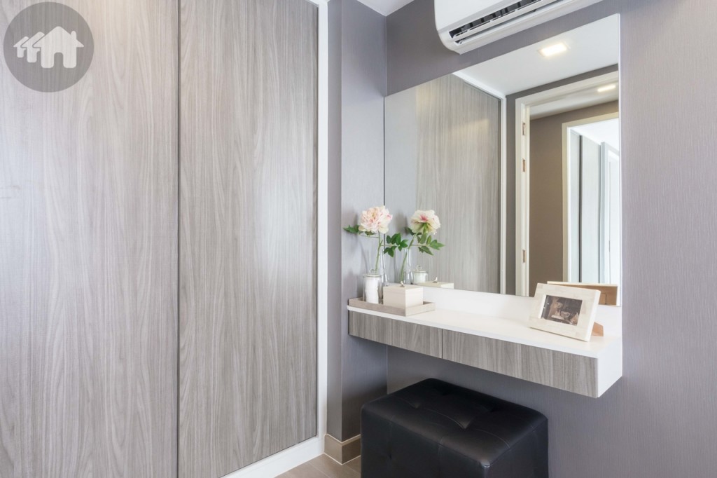A sizable wardrobe and a dressing table are furnished on the other side