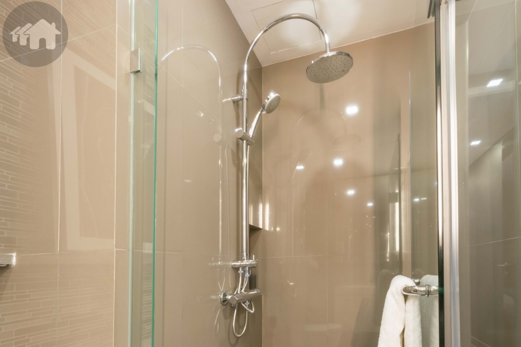The shower room is encased with tempered glass and has a handheld and Rain showers (Kohler branded). The space is around 1x1 metre