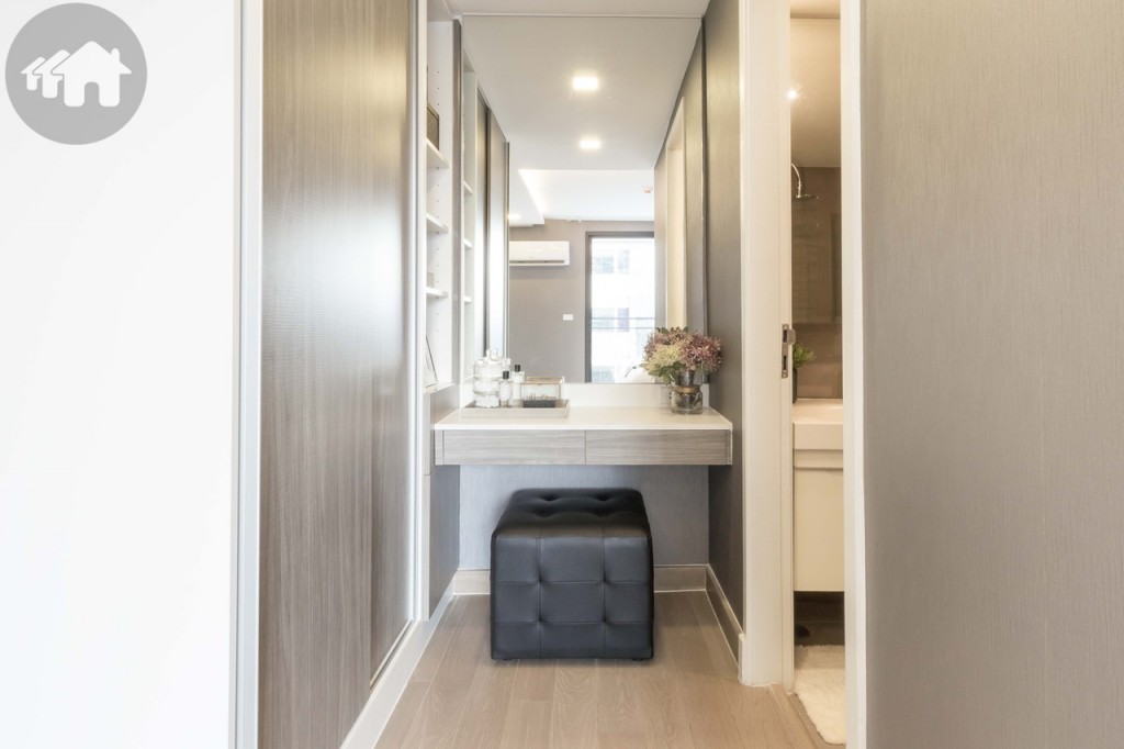 Near the master bathroom’s entrance is a dressing table with drawers, a wardrobe, and a multilevel shelf for storing fashion accessories or cosmetics