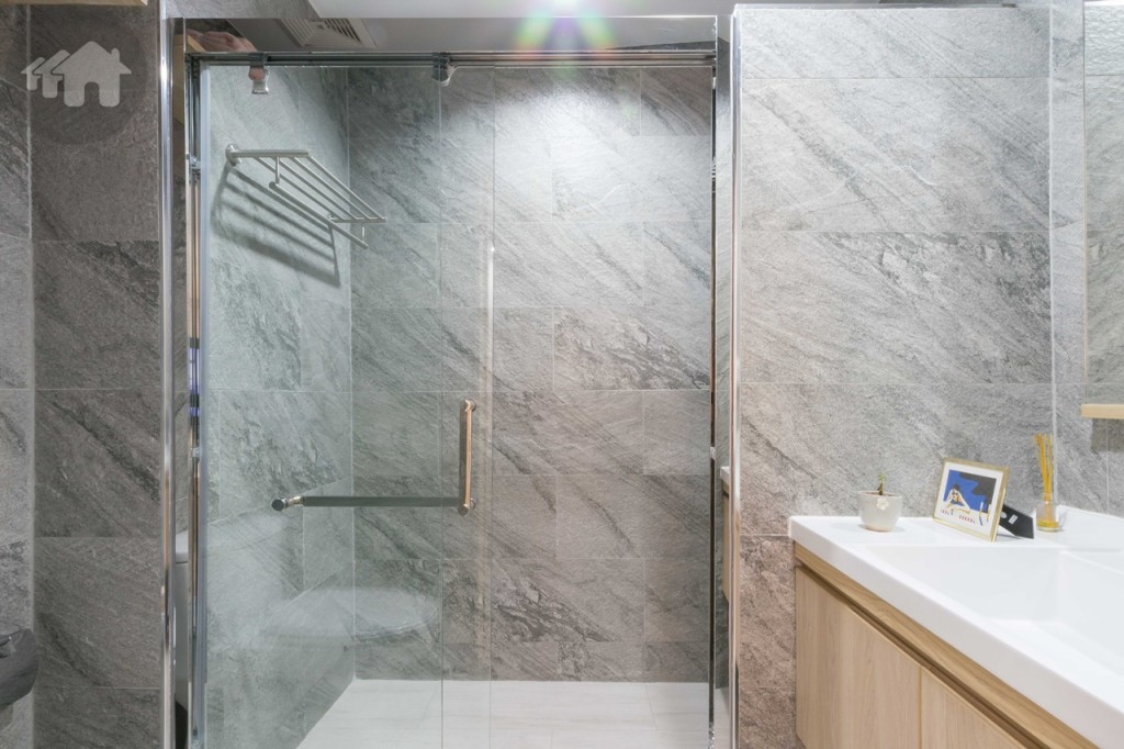 พื้นที่อาบน้ำกั้นเป็นสัดส่วนด้วยประตูกระจกเทมเปอร์แบบบานเลื่อน พร้อมระบบกันกระแทก ขอบประตูยกพื้นสูงประมาณ 10 เซนติเมตร พื้นที่อาบน้ำกว้างประมาณ 90 เซนติเมตร ยาวประมาณ 1.90 เมตร ผนังด้านหนึ่งติดตั้งที่แขวนผ้าขนหนู