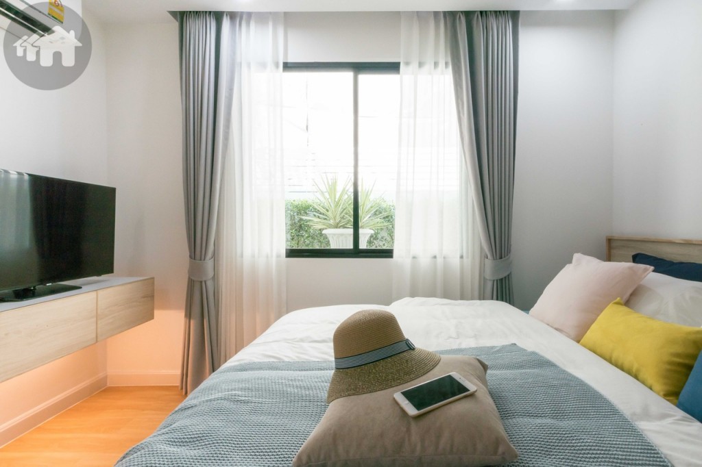 หน้าต่างกระจกบานเลื่อนแบบสลับบานใหญ่เปิดรับแสงธรรมชาติ มาพร้อมผ้าม่านแบบ 2 ราง