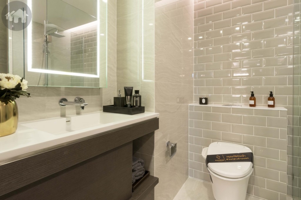 ใกล้กันเป็นห้องน้ำอุปกรณ์ครบครัน พื้นและผนังปูกระเบื้องลายหินอ่อน ส่วนผนังด้านหลังโถสุขภัณฑ์และพื้นที่อาบน้ำปูด้วยกระเบื้องโมเสกเพิ่มความสวยงาม