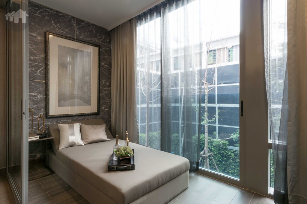 ตกแต่งเป็นห้องนอนเล็กวางเตียงขนาด 3 ฟุตได้สบายๆ ด้านข้างเปิดรับวิวแบบเต็มตาด้วยระเบียงกระจก อีกด้านห่างจากประตูกระจกบานเลื่อนประมาณ 40 เซนติเมตร พื้นปูกระเบื้องลายไม้