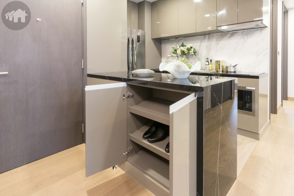 เคาน์เตอร์เตรียมอาหารด้านหนึ่งตกแต่งเป็นชั้นวางรองเท้า ตัวเคาน์เตอร์ห่างจากโต๊ะรับประทานอาหารประมาณ 1.40 เมตร