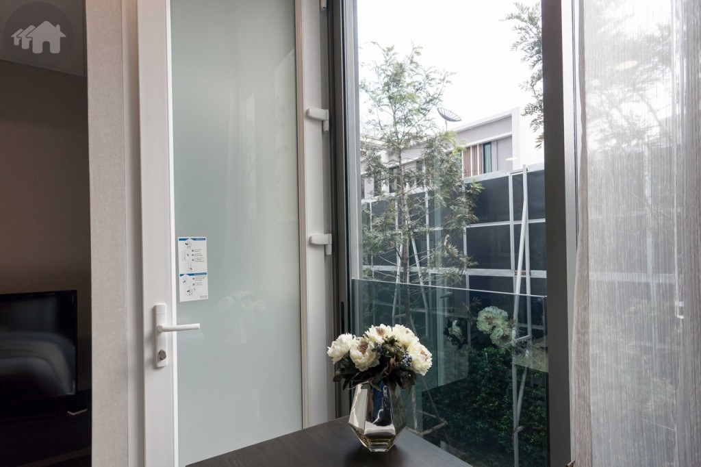 มุมโต๊ะทำงานเปิดรับวิวและลมธรรมชาติด้วยระเบียงกระจก มีประตูเชื่อมต่อไปส่วนระเบียงติดตั้งคอมเพรสเซอร์เครื่องปรับอากาศ