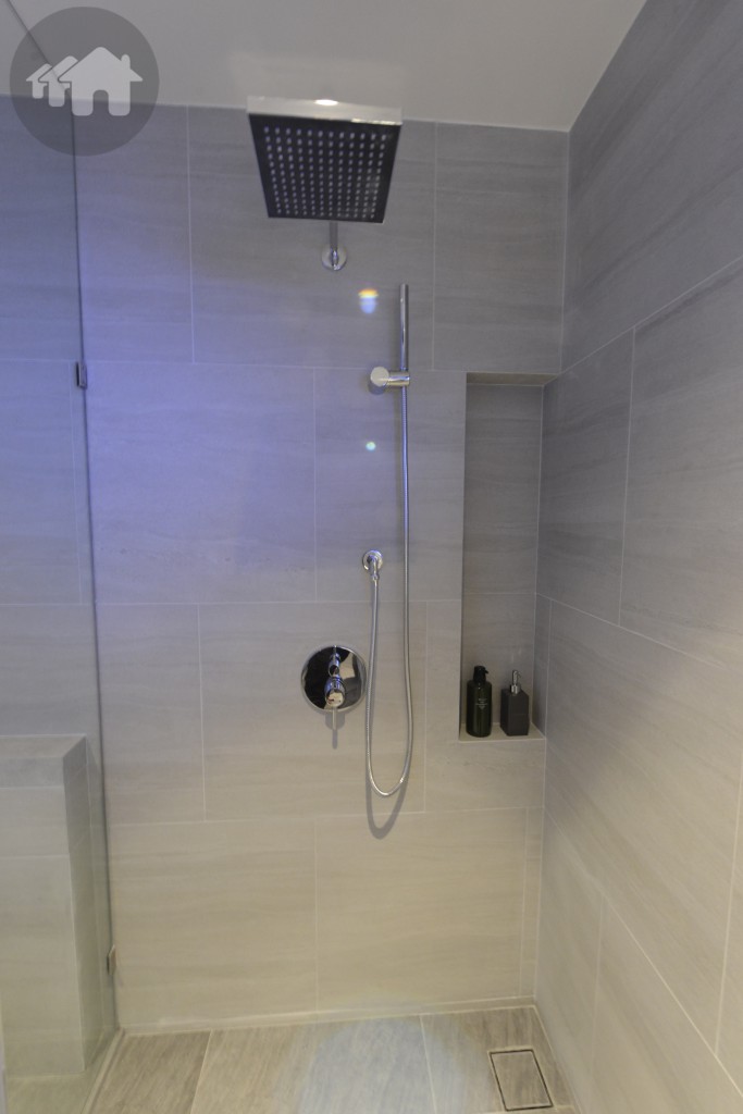 ห้องน้ำกว้าง มีกระจกใสกั้น แยกส่วนอาบน้ำที่เป็นฝักบัว และชักโครก