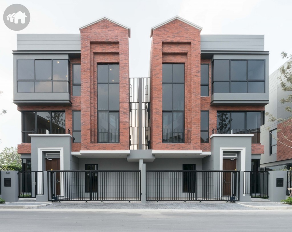 บ้านแฝด 3 ชั้น ด้านหน้าเป็นประตูเหล็กบานเลื่อนแบบสลับ พร้อมประตูเล็กด้านข้าง