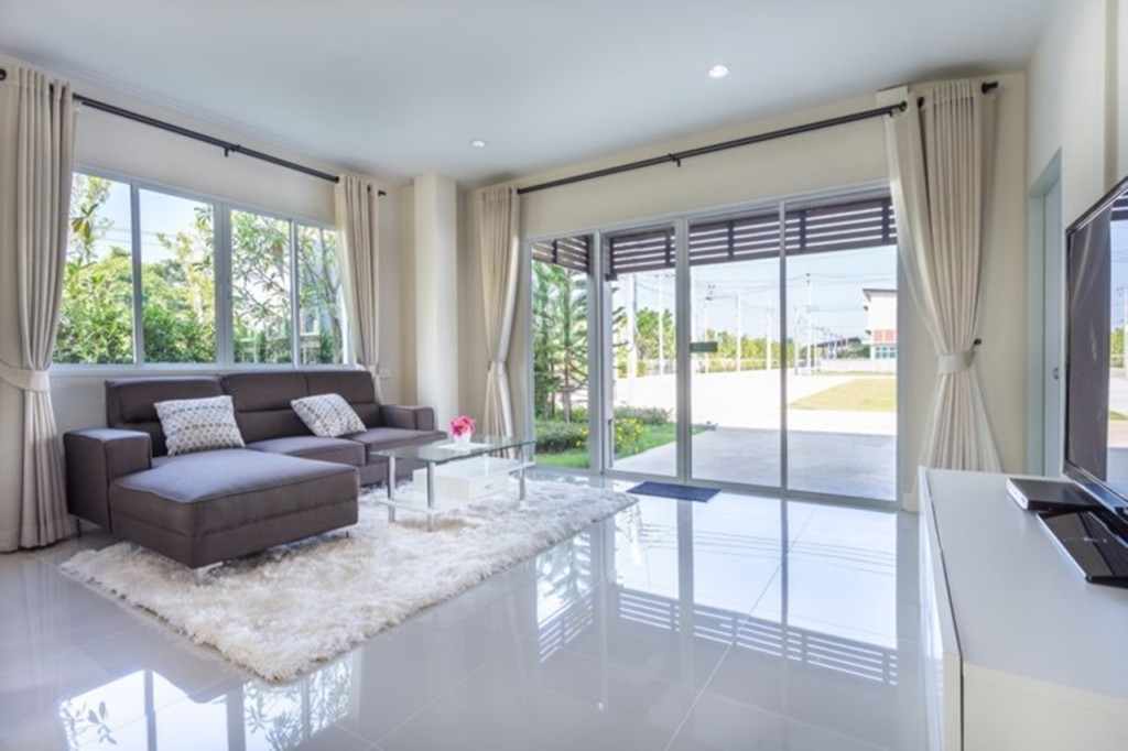 เปิดเข้าไปในตัวบ้านจะเจอกับมุมนั่งเล่น กระเบื้องที่ใช้ปูเป็นแบบแกรนิตโต้ ขนาด 60*60 เซนติเมตร ทั้งชั้นบนและล่าง ทำให้บ้านเย็นสบาย ไม่มีปัญหาวัสดุปูพื้นหลุดร่อน