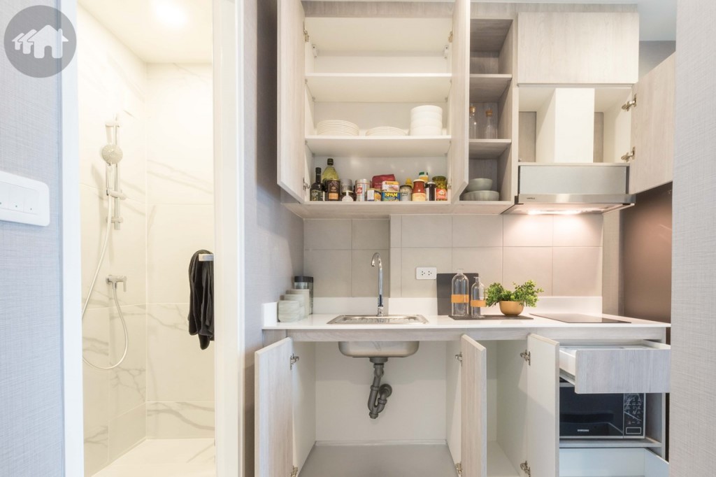 ห้องครัว พื้นปูกระเบื้องขนาด 30x30 เซนติเมตร มาพร้อมตู้ครัวบิลท์อินบน-ล่าง ผนังด้านหลังตู้ครัวปูกระเบื้องขนาด 30x30 เซนติเมตร ทางเดินกว้างประมาณ 90 เซนติเมตร