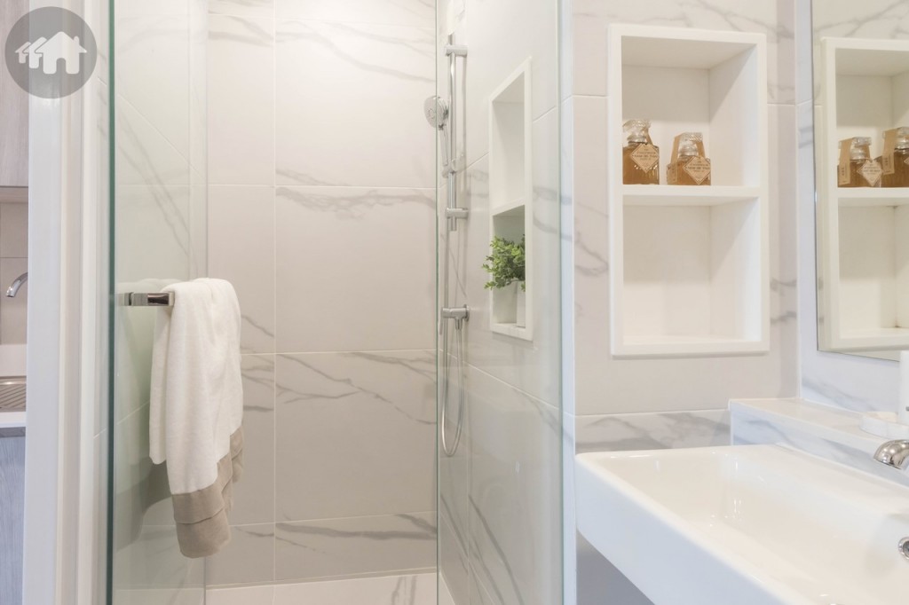 ผนังด้านข้างตกแต่งเป็นชั้นวางอุปกรณ์อาบน้ำ พื้นที่อาบน้ำกั้นเป็นสัดส่วนด้วยกระจก Tempered Glass ขอบประตูยกพื้นสูงประมาณ 5 เซนติเมตร พื้นที่อาบน้ำกว้างประมาณ 85 เซนติเมตร ยาวประมาณ 90 เซนติเมตร พร้อมฝักบัวของ Hafele