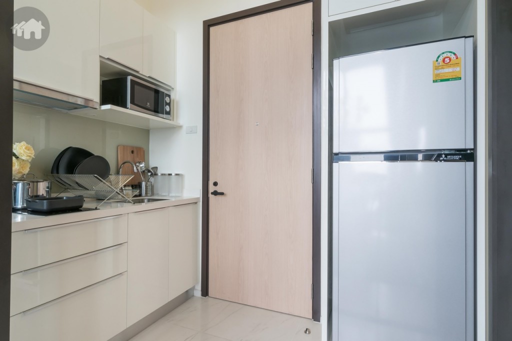 โซนด้านหน้าห้องเป็นห้องครัว เคาน์เตอร์ครัวห่างจากตู้ครอบตู้เย็นและที่วางรองเท้า (ด้านล่างของตู้ครอบ) ประมาณ 1.15 เมตร เดินเข้า-ออกสะดวก พื้นปูกระเบื้องลายหินอ่อน ขนาด 60x60 เซนติเมตร