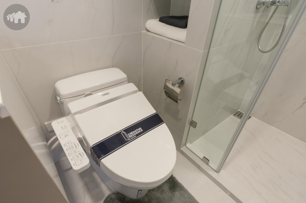 โถสุขภัณฑ์แบบ Washlet ของ TOTO พร้อมสายฉีดชำระ และที่ใส่กระดาษชำระ