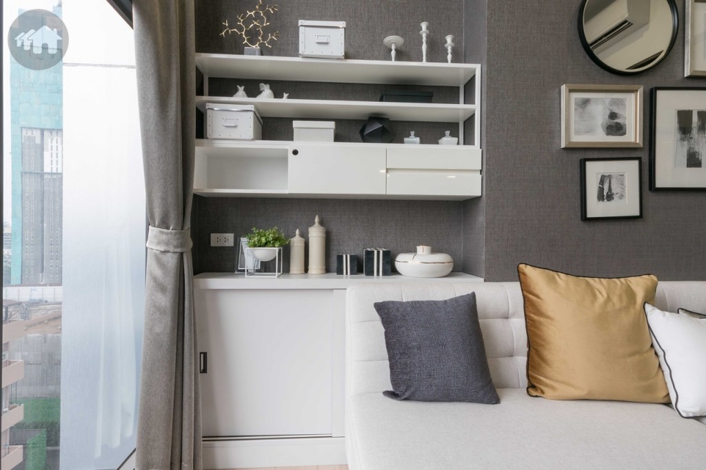 ด้านหลังโซฟาด้านบนเป็นชั้นวางของติดผนัง ด้านล่างเป็นตู้เก็บของที่แถมมากับห้อง