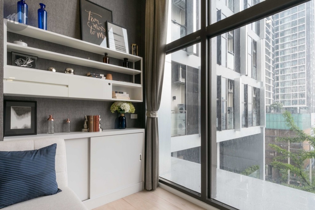 ด้านหลังโซฟา ด้านบนเป็นชั้นวางของติดผนัง ด้านล่างเป็นตู้เก็บของที่แถมมากับห้อง