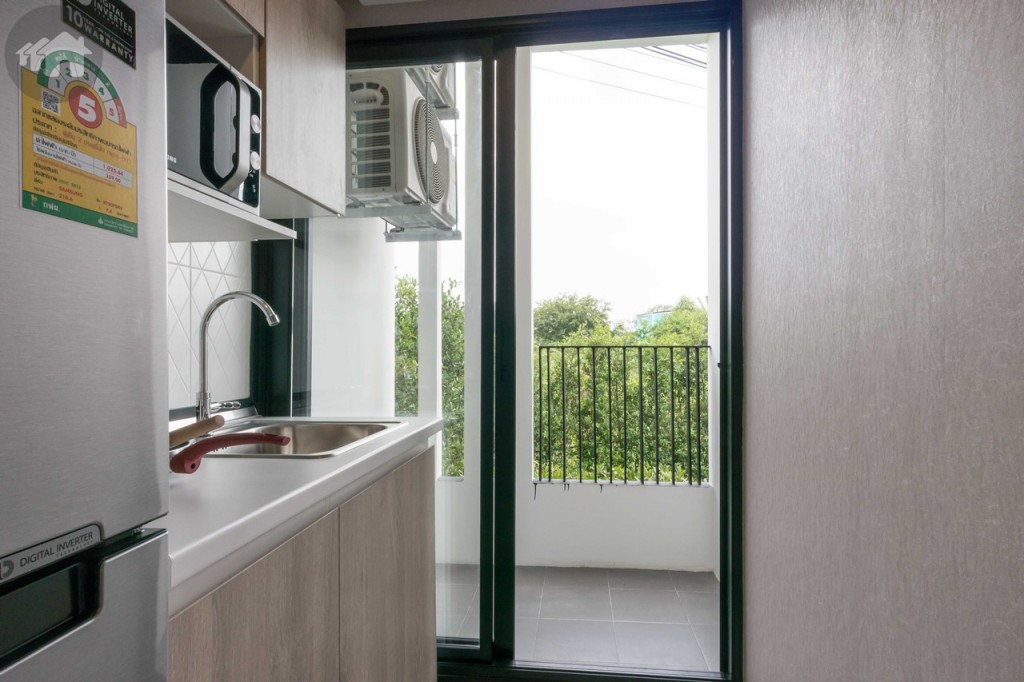 ห้องครัวเชื่อมต่อกับระเบียงด้วยประตูกระจกบานเลื่อนแบบสลับ ขอบประตูยกสูงประมาณ 15 เซนติเมตร