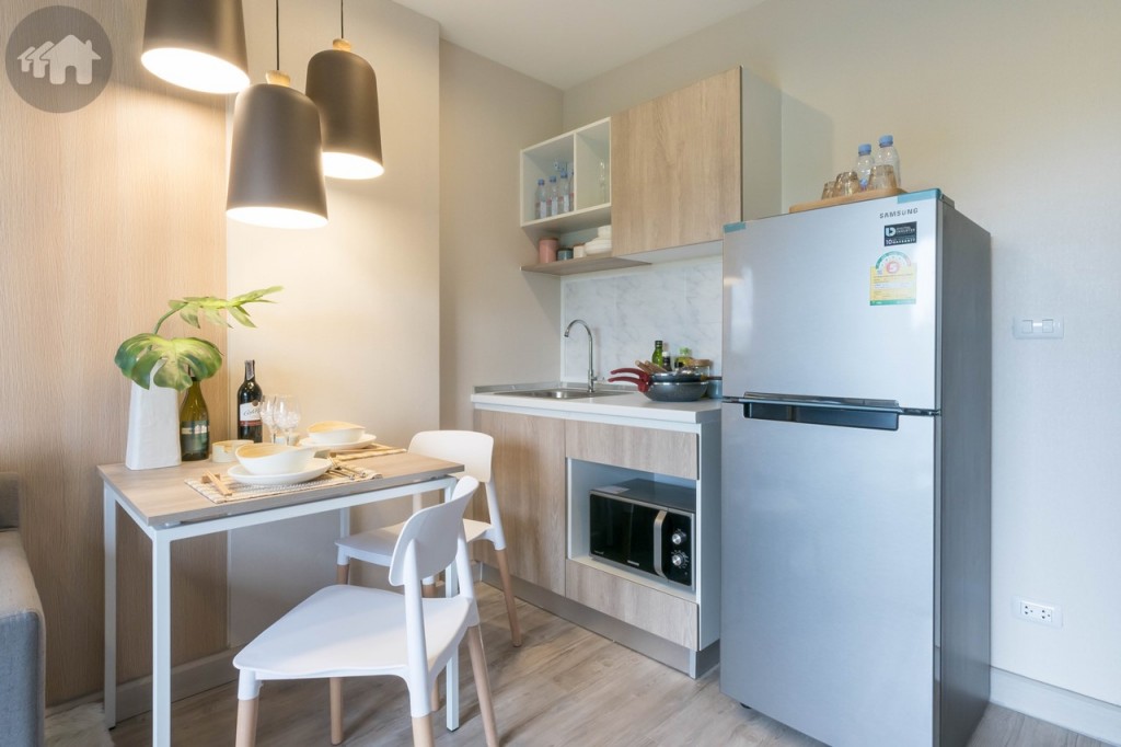 ห้องครัวขนาดใหญ่ มาพร้อมตู้ครัวบิลท์อินบน-ล่าง อ่างล้างจานของ Hafele ผนังด้านหลังเคาน์เตอร์ครัวปูกระเบื้องขนาด 25x35 เซนติเมตร โต๊ะรับประทานอาหาร พร้อมเก้าอี้ 2 ตัว ด้านข้างเหลือพื้นที่กว้างประมาณ 1 เมตร วางตู้เย็นขนาด 7.4 คิว ได้สบาย