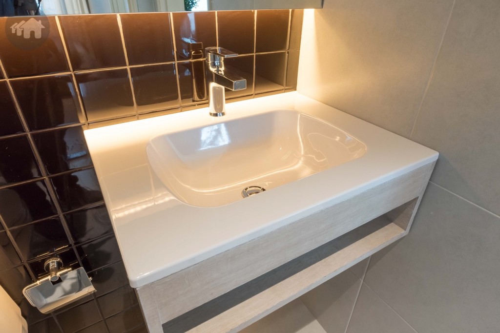 อ่างล้างหน้า และก๊อกน้ำของ Kohler เคาน์เตอร์ด้านล่างเป็นชั้นวางของ