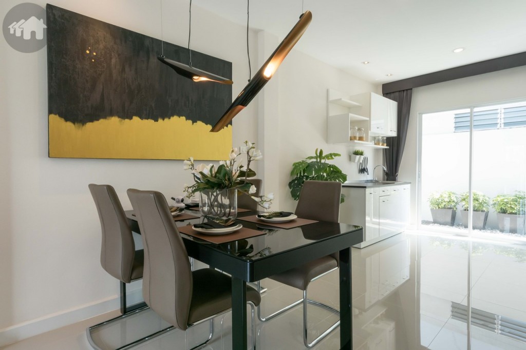 ถัดเข้าไปเป็นโต๊ะอาหาร พื้นชั้นล่างเป็นกระเบื้องแกรนิตโต 60*60 เซนติเมตร ส่วนฝ้าเพดานภายในเป็นยิปซั่มฉาบเรียบทาสีพลาสติก ฝ้าภายนอกเป็นยิปซั่มกันชื้นฉาบเรียบ