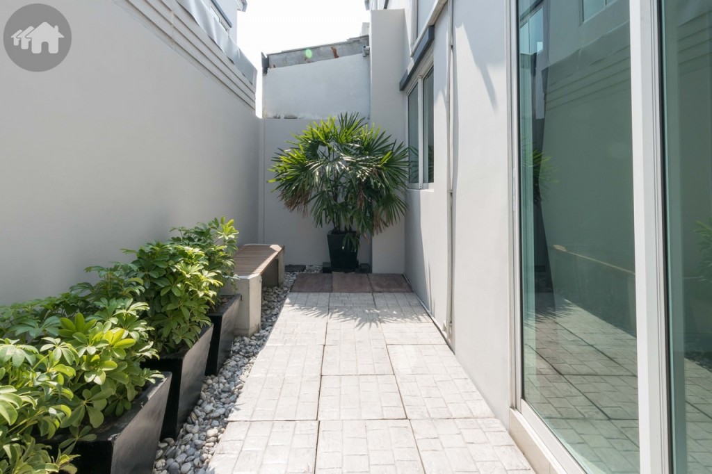 เปิดประตูบานเลื่อนกระจกด้านข้างออกไปจะเจอกับพื้นที่ขนาดกำลังดีเหมาะกับการจัดสวนเล็กสำหรับนั่งเล่น หรือต่อเติมเป็นครัวไทย